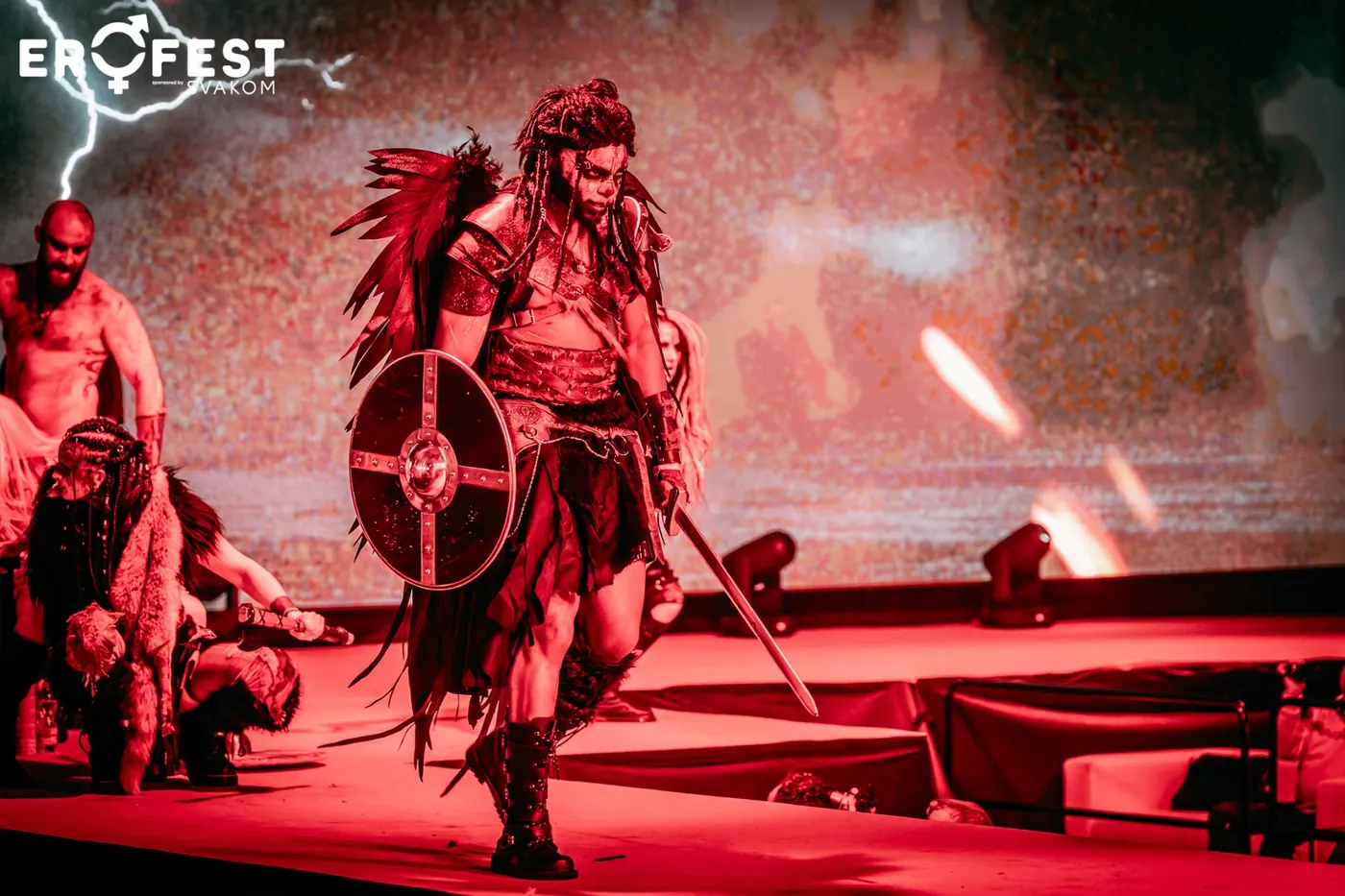 A costumed fight show under red spotlights